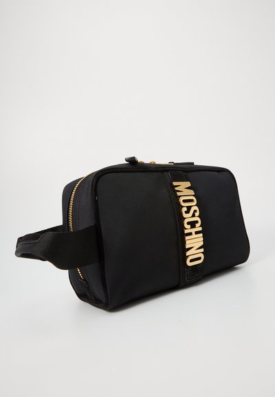 Pungă cosmetică din material textil negru, cu accesorii aurii, închidere cu fermoar și un logo proeminent "MOSCHINO" pe față. Formă rectangulară cu maner.