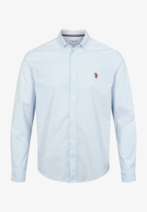 Fénykék gombos ing normál gallérral, függőleges csíkokkal, hosszú ujjakkal, és egy kis hímzett logóval a bal mellen.