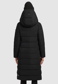 Black long puffer coat with a hood, featuring a quilted design and textured fabric. Includes a side zip and a logo detail at the hem.