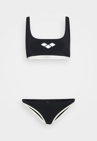 Bikini nero con top a scollatura quadrata, caratterizzato da bordi bianchi e un logo, abbinato a slip a vita bassa con accenti bianchi laterali.