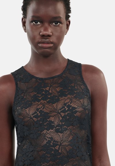 Svart blonder tank topp med blomster mønster, uten ermer design, og rund hals. Laget av delikat, strukturert blonder stoff.