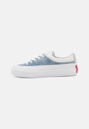 Niska tenisówka z jasnoniebieską cholewką wykonaną z materiału, białymi sznurówkami, grubą białą podeszwą i czerwonym detalem na pięcie.