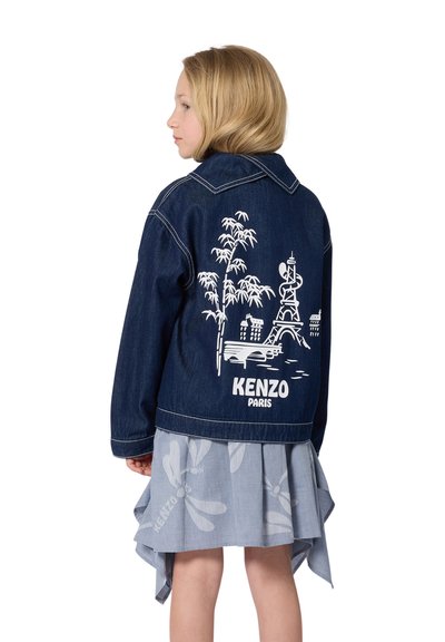 Veste en denim avec impression graphique blanche de la Tour Eiffel et de bambou à l'arrière. Elle présente un col classique et une fermeture à boutons.