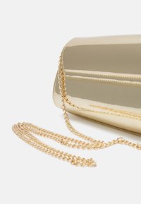 Borsa a tracolla in oro con finitura liscia, caratterizzata da una tracolla a catena e un design elegante e arrotondato. Nessun motivo o accentuazione visibile.