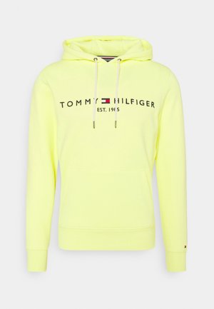 Lysegul Tommy Hilfiger hættetrøje med frontlomme, snøre i hætten og logotekst med flag samt "EST. 1985" på brystet.
