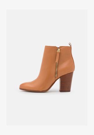 Hellbraune Lederknöchel-Stiefel mit einem seitlichen Reißverschluss und chunky Holzabsatz. Glatte Textur, spitze Zehenform und dekorative goldfarbene Hardwaredetails.