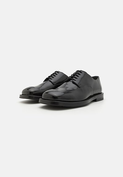 Black leather dress shoes with a polished finish, rounded toes, lace-up design, and a low profile rubber sole.