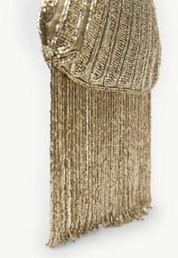 Guldperle clutch med en buet, tekstureret top og fransede kanter, som har indviklede mønstre og en glat metalfinish.