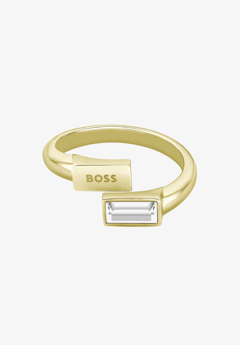 Anillo en tono dorado con una piedra rectangular clara y un bloque rectangular grabado con "BOSS", diseño elegante y pulido.