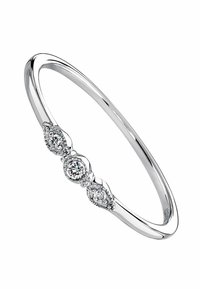 Brazalete de plata con tres diamantes redondos engastados en un diseño de lágrima, con un acabado suave y pulido y delicados acentos.