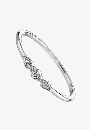 Brazalete de plata con tres diamantes redondos engastados en un diseño de lágrima, con un acabado suave y pulido y delicados acentos.