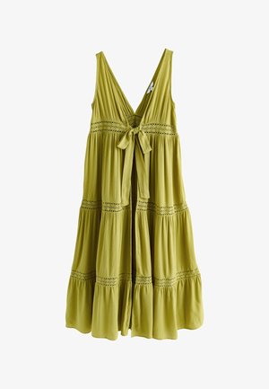 Robe sans manches vert olive clair avec un décolleté en V profond, un nœud noué à la taille et une jupe à volants avec des détails en dentelle.