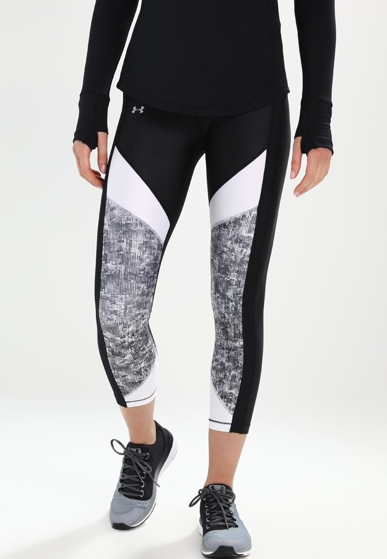 Svart och vita atletiska leggings med texturerade grå detaljer, med en åtsittande design och kontrasterande triangulära paneler.