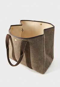 Καφέ τσάντα tote με υφή, σκούρες καφέ ραμμένες λαβές και μπεζ εσωτερικό, ανοιχτή κορυφή με χρυσά κουμπιά σ snap κατά μήκος των άκρων.