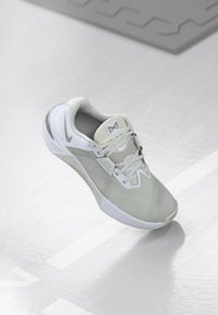 Athletic shoe in light gray and white, featuring mesh material, textured surface, padded collar, and a reinforced rubber sole for grip.