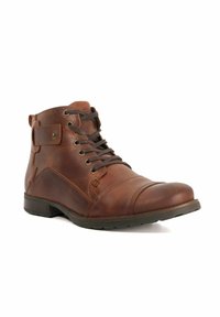 Brown leather ankle boot with a rounded toe, lace-up front, and side strap detail. Features a textured finish and a rubber sole.