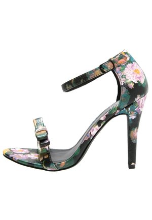 Open-toe hoge hak sandaal in zwart leer met een levendige bloemenprint. Voorzien van een verstelbare enkelband en een gespsluiting.