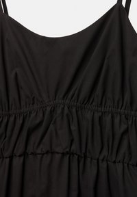 Robe noire sans manches avec un tissu froncé au niveau de la poitrine et de la taille, présentant une texture douce et un design simple.