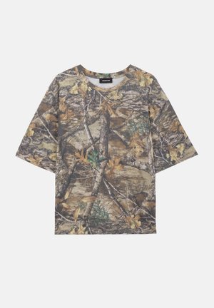 T-shirt à manches courtes camouflage avec un motif forestier de feuilles brunes, branches d'arbres et mousse verte, présenté à plat sur un fond clair.