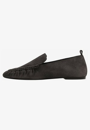Mocassins en daim noir avec un bout arrondi, un design supérieur froncé et un petit talon. Dispose d'un onglet à l'arrière pour un enfilage facile.