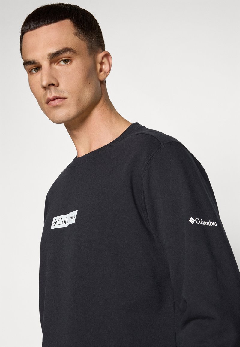 Sweatshirt noir en mélange de coton, avec une patch logo blanc rectangulaire sur la poitrine et un logo blanc plus petit sur la manche.