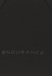 Mustakuntoinen kangas, jossa on urheilullinen rakenne ja kohokuvioitu "ENDURANCE"-logo. Suora muotoilu, ei näkyviä kuvioita tai koristeita.