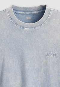 Šviesiai mėlynas puloveris su apykakle, pagamintas iš medvilnės, turintis minkštą tekstūrą ir išsiuvinėtą Levi's logotipą krūtinėje.