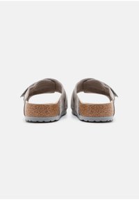 Gray back view of sandals featuring a cork footbed and a durable rubber sole, with a soft upper and open design for ventilation.