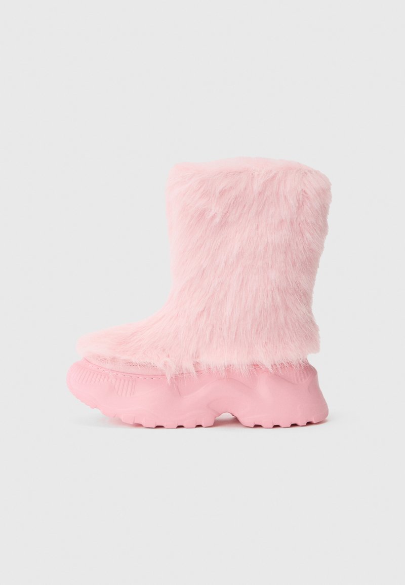 Dudoros rózsaszín csizma, texturált talppal és puha, bolyhos műszőrme borítja az egész felső részt.
