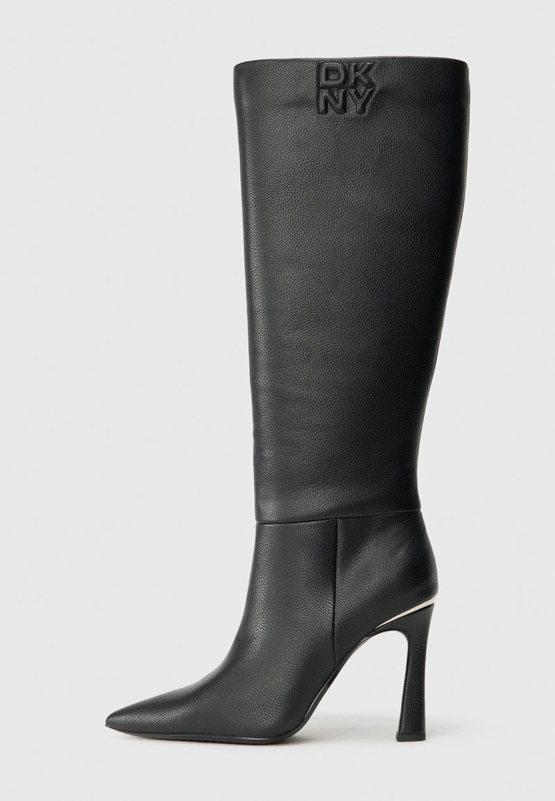 Černé kožené vysoké stiletto kozačky s špičatou špičkou a embosovaným logem DKNY blízko horního okraje na jednobarevném pozadí.