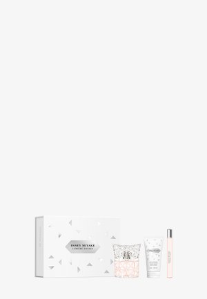 Set de parfum, lotion pour le corps et roll-on Issey Miyake Lumière d'Issey avec emballage décoratif blanc sur fond blanc.
