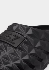 Must tekstuuriga libisev sandaal geomeetrilise mustriga ja EA Emporio Armani logo rihmal.