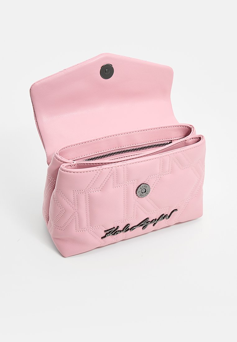 Pochette en cuir rose avec un motif matelassé géométrique, deux compartiments, fermeture éclair et fermeture à bouton magnétique. Présente le logo "Hold My Bag" en noir.