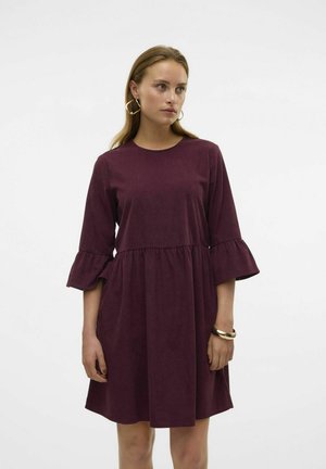 Robe évasée bordeaux à manches évasées, avec un col rond et une taille froncée. Fabriquée en tissu doux, mi-longue avec une silhouette fluide.