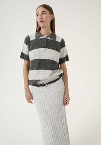 Gray and white striped wool polo shirt with short sleeves, featuring a collar and buttons, paired with a ribbed gray skirt and a black belt.