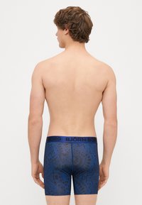 Boxer briefs azuis com um padrão escuro texturizado. O cós elástico apresenta a marca "BJÖRN BORG". O material parece elástico e ajustado.
