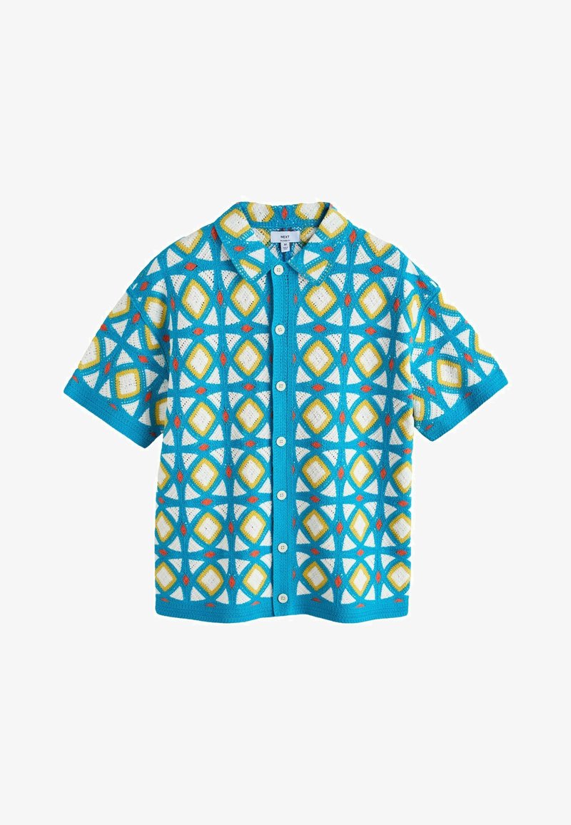Chemise à manches courtes avec boutons, motifs géométriques en forme de losanges bleu, blanc, jaune et rouge, et col ouvert.
