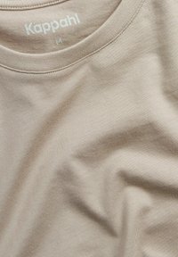 Beige bomulds T-shirt med rund halsudskæring og blød tekstur. Har "Kappahl" logo i lys farve og størrelseslabel "M" indeni kraven.