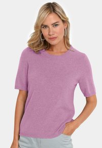 Helles rosa kurzärmliges Sweater mit rundem Halsausschnitt, hergestellt aus weichem Strickmaterial. Verfügt über eine lockere Passform und gerippte Säumendetails.