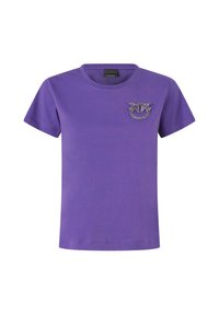 Ljubičasta pamučna majica s kratkim rukavima, okruglim izrezom i logotipom ukrašenim kristalima na lijevoj strani prsiju. Glatka tekstura.