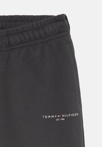 Gray sweatpants made of soft cotton with an elastic waistband. Features a small white logo and year "1985" on the left hip.