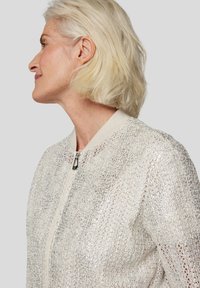 Leichter Bomberjacke aus strukturiertem, metallic-silbernen Stoff. Mit einem gerippten Kragen und einem Reißverschluss. Einfaches Design, keine Muster.