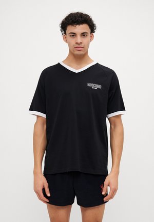 Black short-sleeve T-shirt with white V-neck and sleeve trim, featuring a Moschino logo on the chest. Soft, lightweight material.