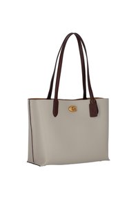 Beige tote taske med brune læderhåndtag, guldfarvet hardware og en struktureret overflade. Har et kontrasterende brunt mærke og et struktureret design.