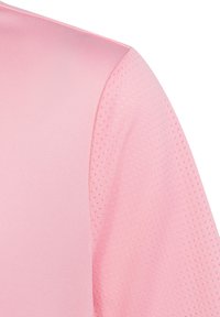Lichtroze sportstof met een gladde textuur en een ademend gaaspatroon op de schouder. Heeft een slanke, gestroomlijnde vormgeving.