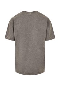 Camiseta de algodón gris con un corte relajado. Mangas cortas, escote redondo y una textura ligeramente desvaída. Detalles de costura alrededor del escote y el dobladillo.