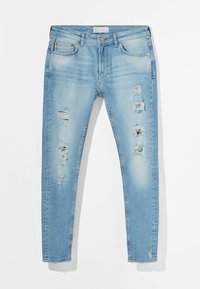 Ljusblå slitna jeans i denim med trasiga detaljer och fransiga fållar. Har fem fickor och dragkedja med knappstängning.