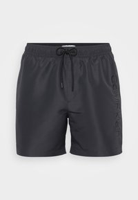 Shorts de bain noirs en tissu léger, dotés d'une taille élastique avec cordon de serrage et d'un logo "Calvin Klein" embossé sur le côté.