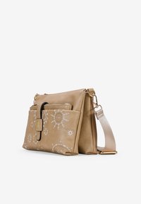 Bolso cruzado de cuero beige con patrones de sol bordados, con un bolsillo frontal, herrajes dorados y una suave correa para el hombro.