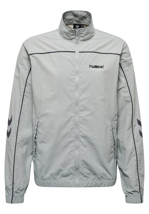 Lichtgrijze sportjacket met een volledige rits, staande kraag en elastische mouwen. Heeft zwarte accenten en het logo op de borst.